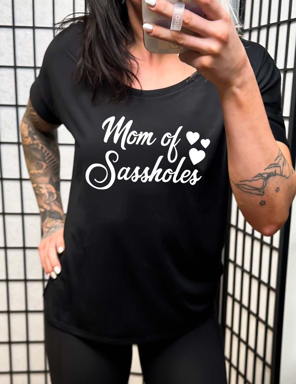 black slouchy tee with the words "mom of sassholes" on it, with three little hearts next to the words