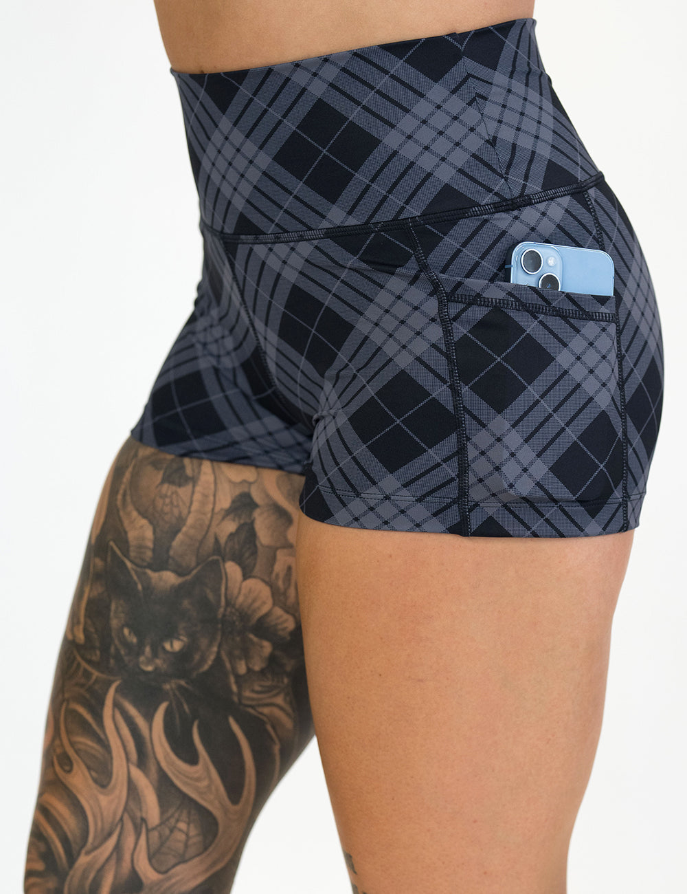 close up of the 2.5 inch monochrome colored plaid shorts with a phone in the pocket