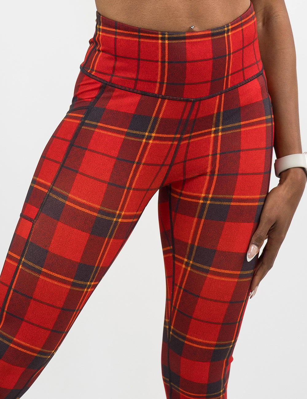 front of the red, yellow, and dark grey plaid leggings against a white background