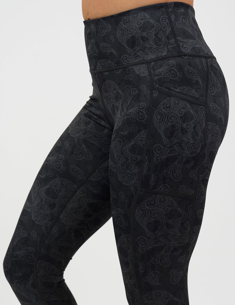 close up of dark pirate themed skull and cross bones leggings against a white background
