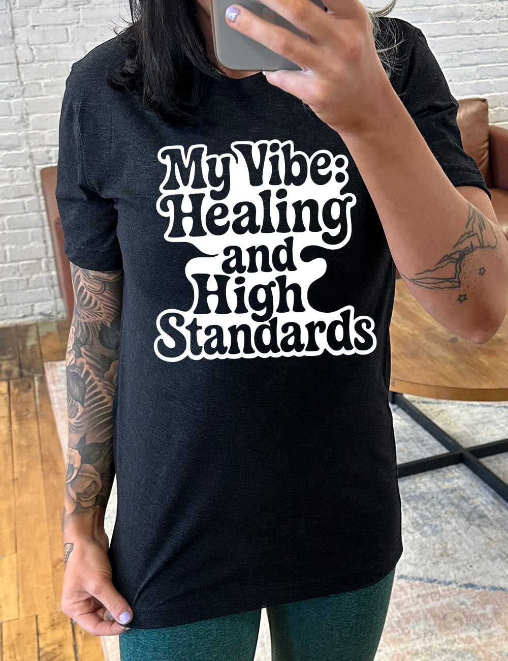 black unisex tee with the words "my vibe: healing and high standards" on it