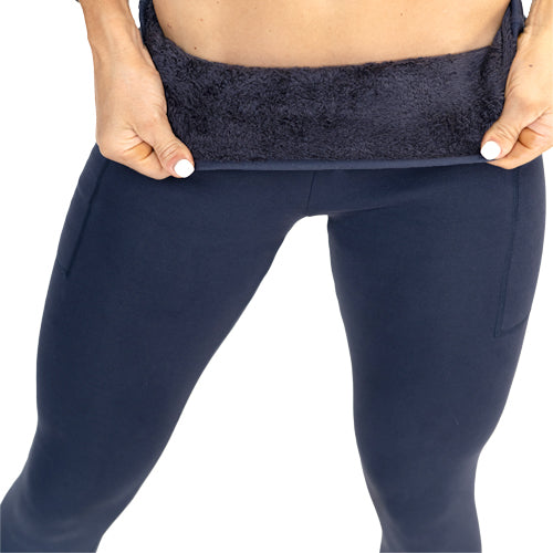 close up of navy fleece lined leggings, model is flipping the leggings to show the fleece on the inside.