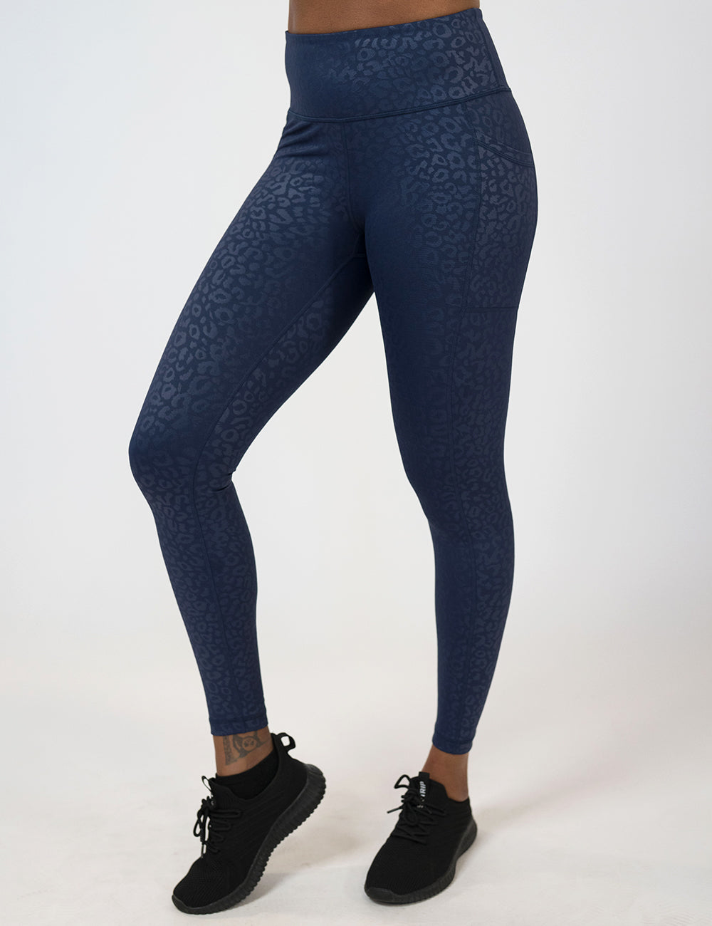 model wearing the full length dark blue leopard print leggings against a white background
