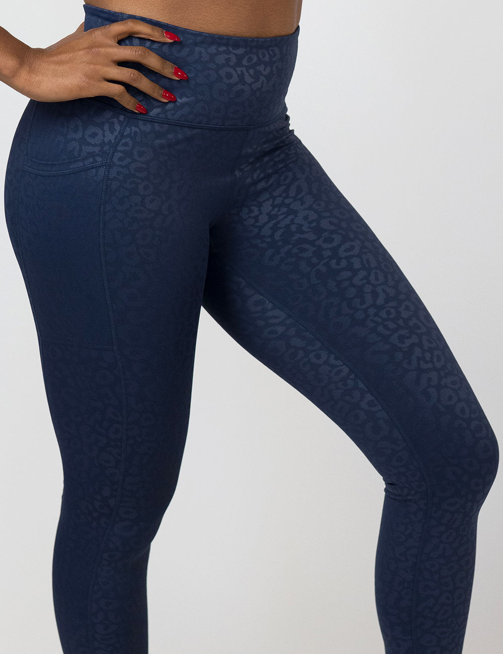 front of the dark blue leopard print leggings against a white background