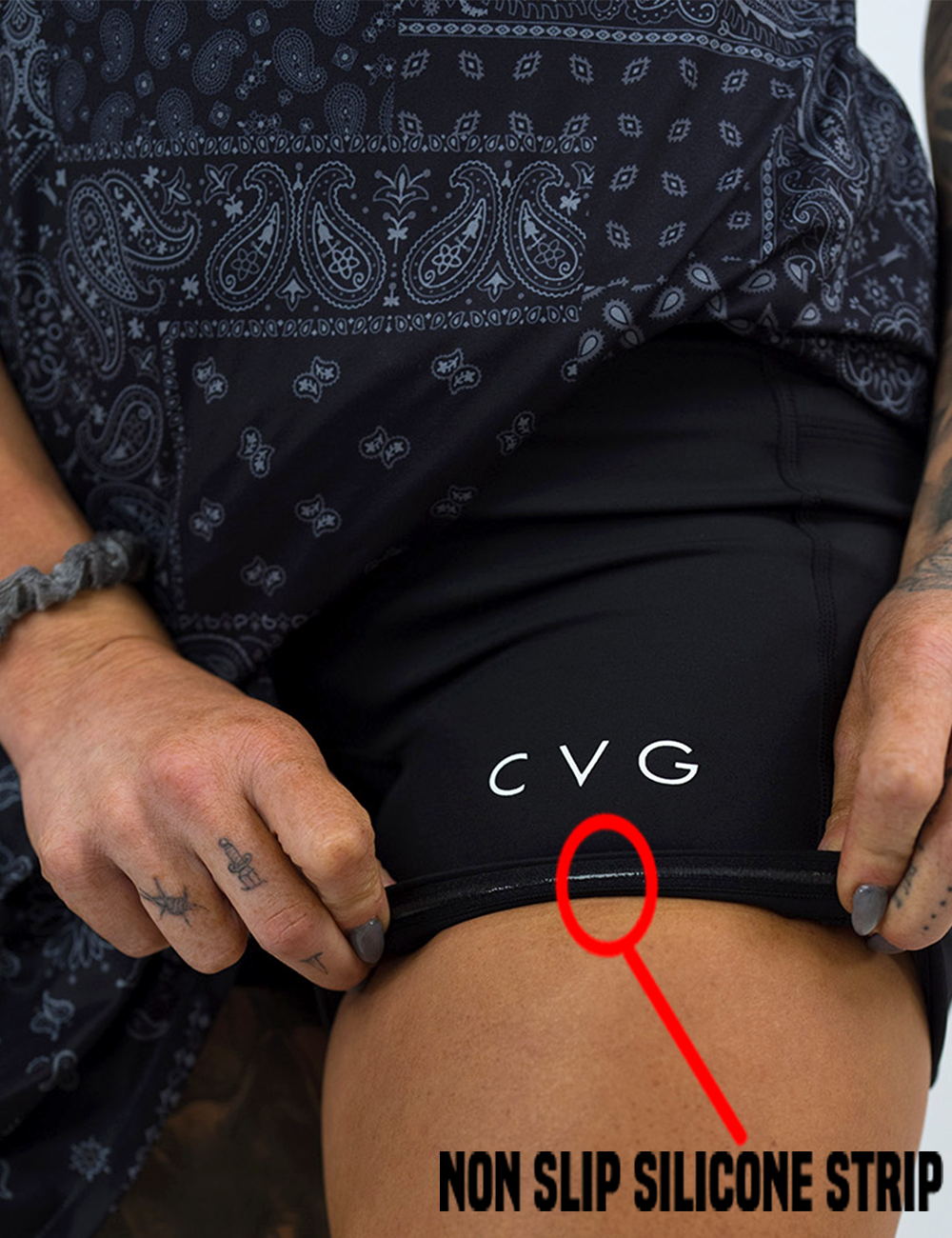 the black active dress with white accents lifted up to show the non slip silicone strip lining the built in shorts