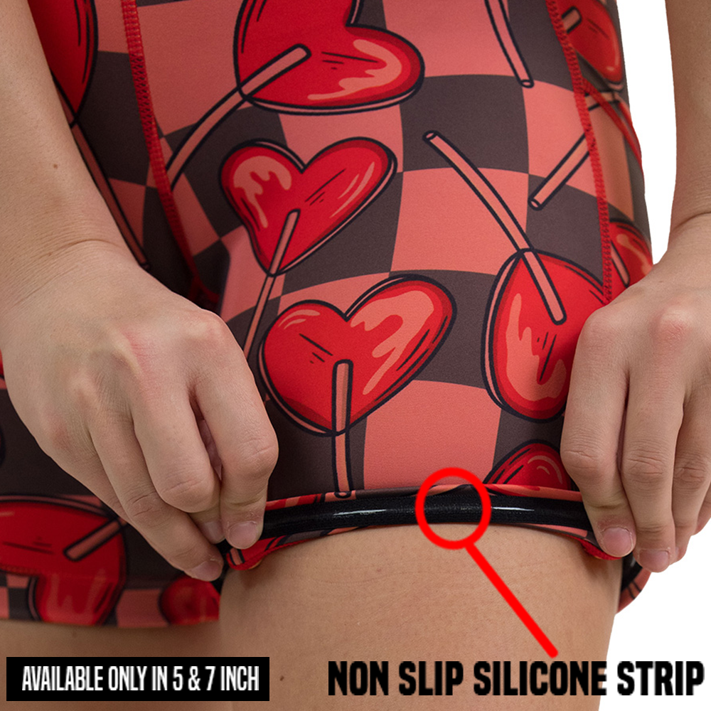 close up of rolled up heart lollypops on a checker board pattern shorts showing the non slip silicone strip along the inside of the 5 and 7 inch shorts