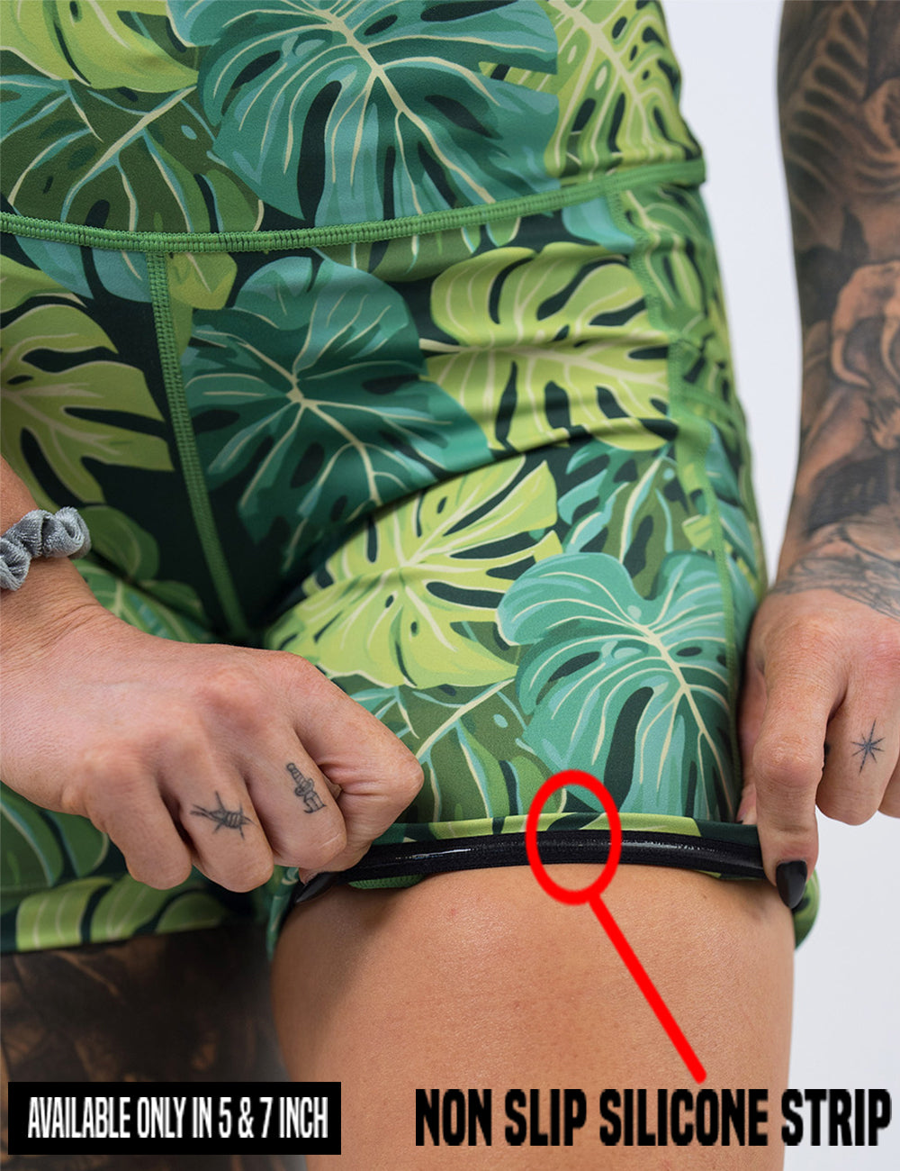 close up of the green tropical leaves shorts being rolled up to show the non slip silicone strip found in the 5 and 7 inch inseam sizes
