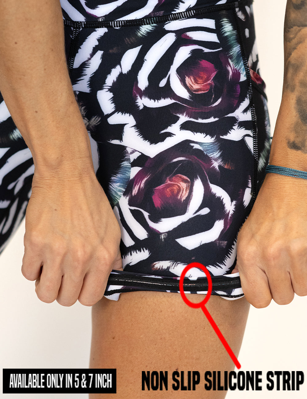 close up of the blue, pink, white petal design shorts lifted up to show the non slip silicone strip found inside the 5 and 7 inch inseam lengths