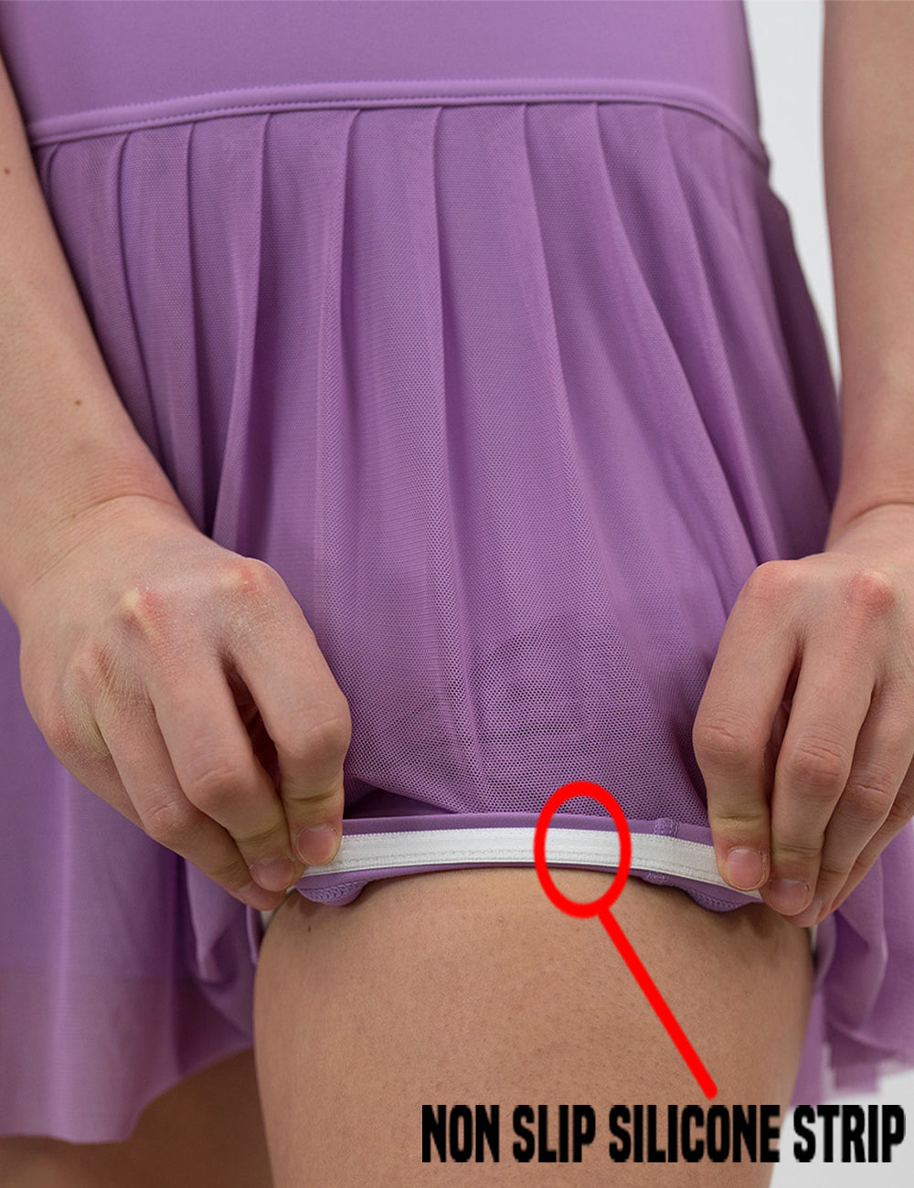 close up of the purple sheer skirt being rolled up to show the non slip silicone lining in the shorts underneath