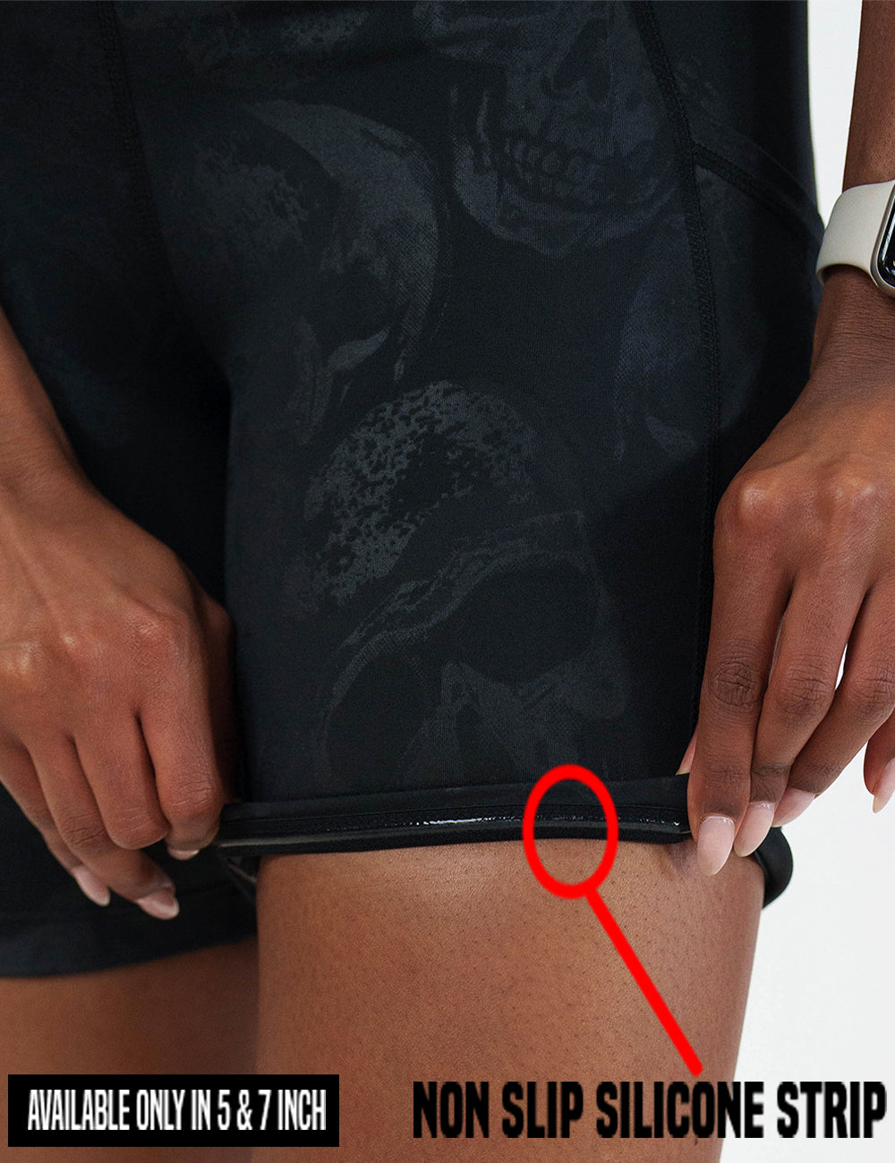 close up of the black shorts with a dark grey skull pattern being rolled up to show the non slip silicone strip found in the 5 and 7 inch shorts 