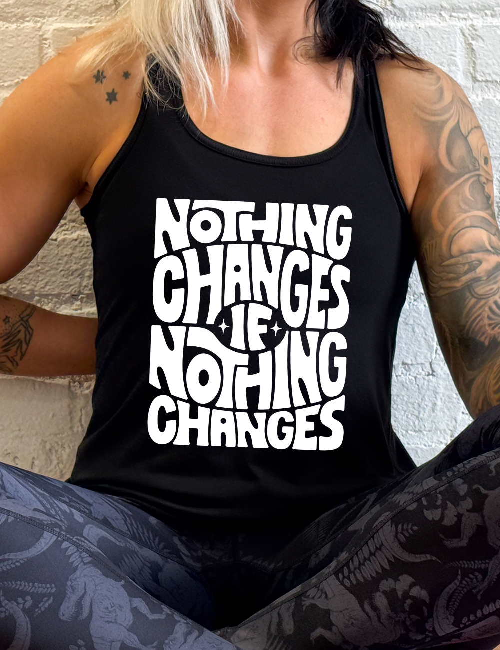 black racerback flowy tank with the words "nothing changes if nothing changes" on it, with two tiny stars on either side of the word "if"