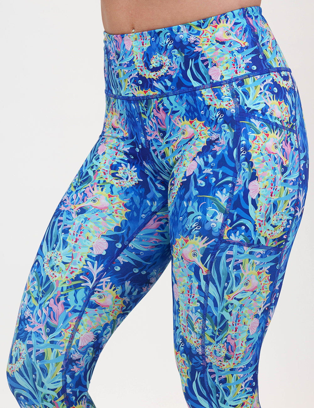 front of the colorful seahorse patterned leggings against a white background