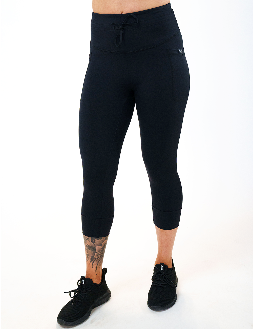 model wearing the capri omni black drawstring leggings against a white background
