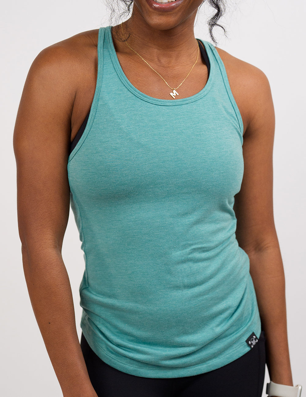 front of the teal open back tank top against a white background