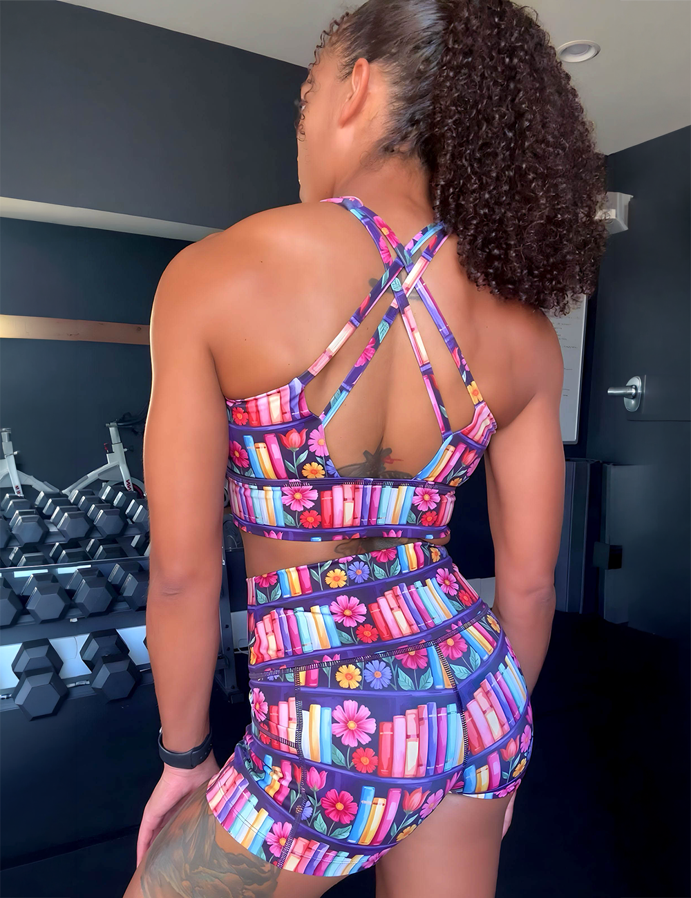 model wearing the 2.5 inch colorful bookshelves and flowers shorts in the gym