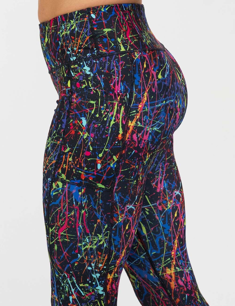 back of the rainbow paint splatter against a black background leggings 
