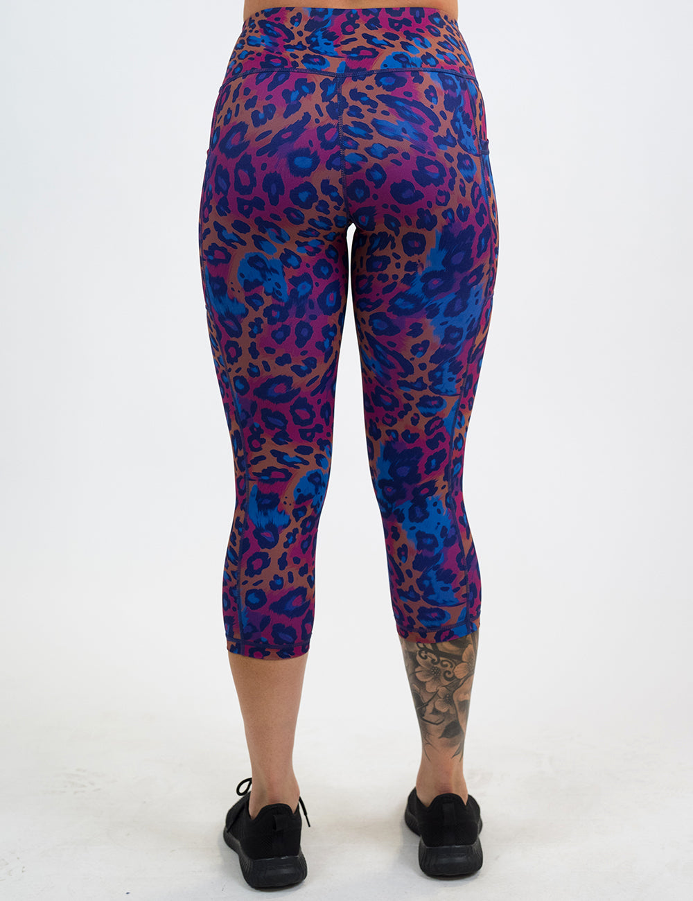 back of the capri red, yellow, and blue cheetah print leggings against a white background against a white background