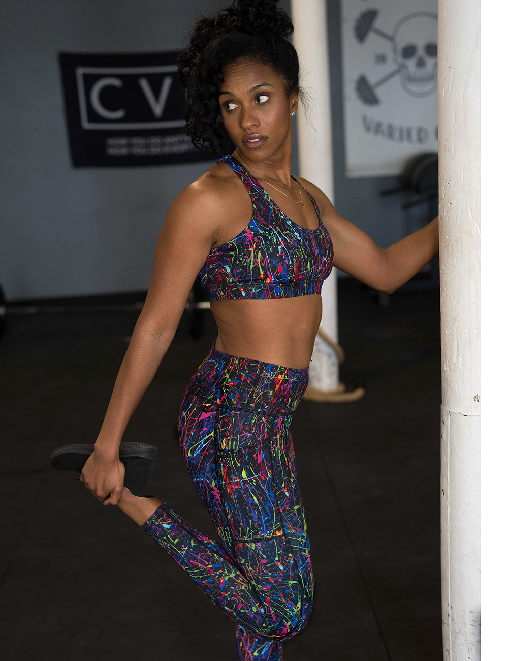 model wearing the full length rainbow paint splatter leggings in the gym