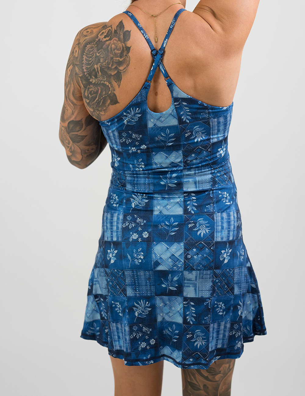 back of the regular length blue patchwork flowers dress against a white background