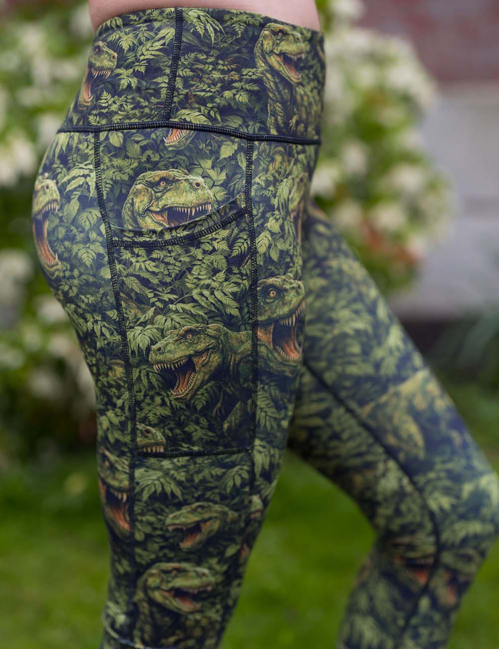 close up shot of t-rex leggings that're green