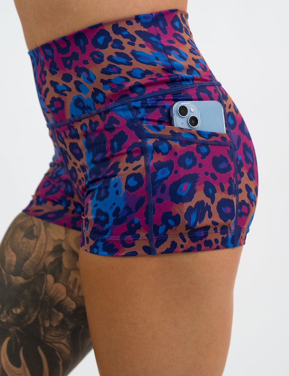 close up of the 2.5 inch  yellow, red, and blue leopard print shorts with a phone in its pocket