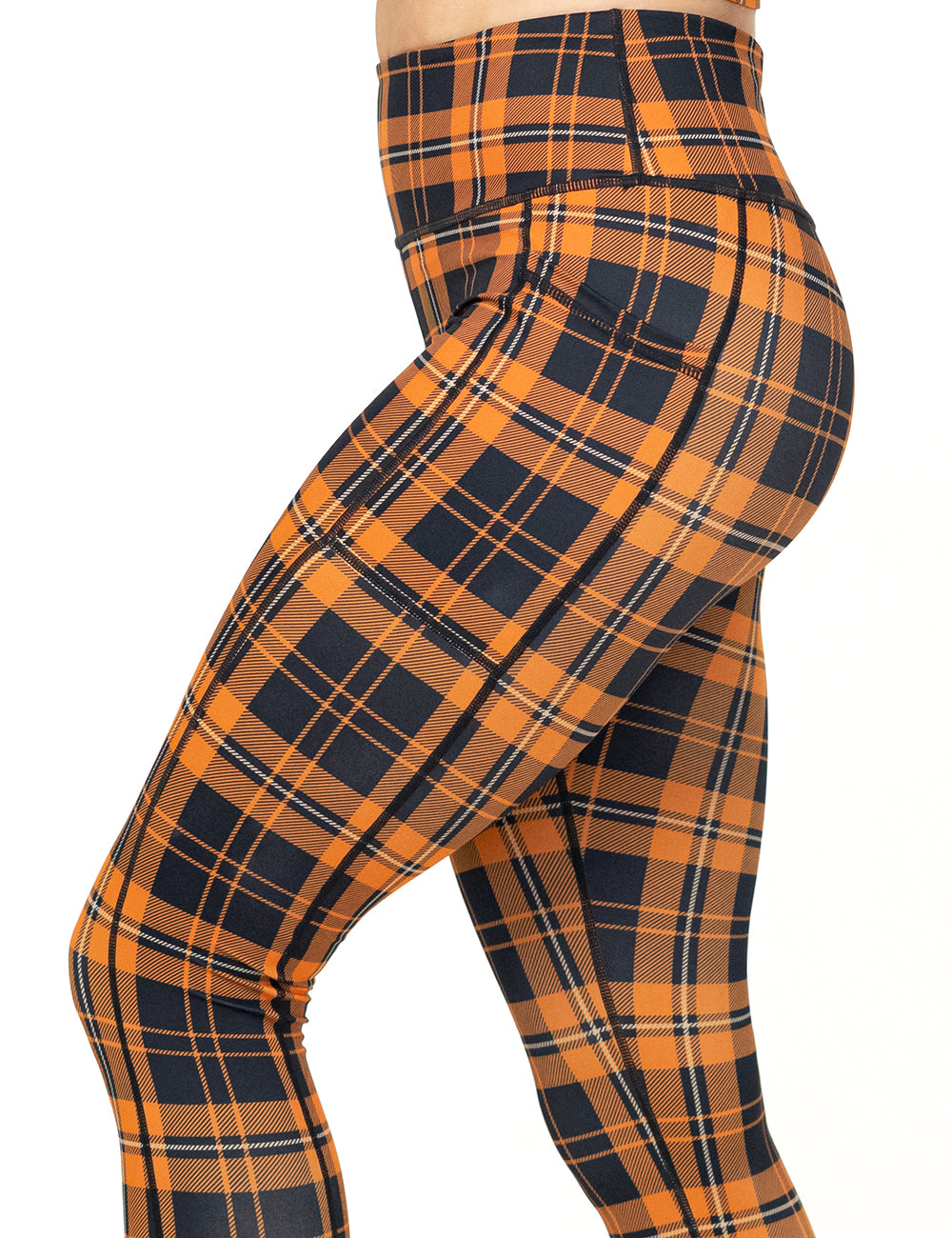 side view of the orange and black plaid leggings against a white background