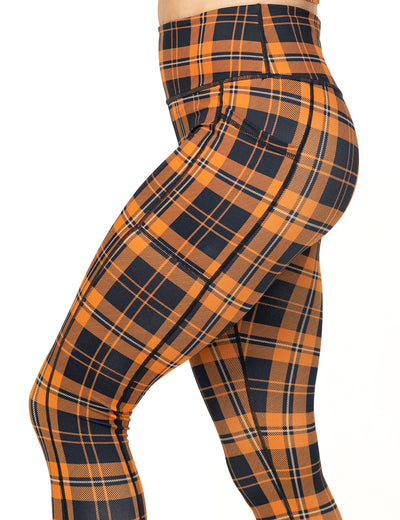side view of the orange and black plaid leggings against a white background