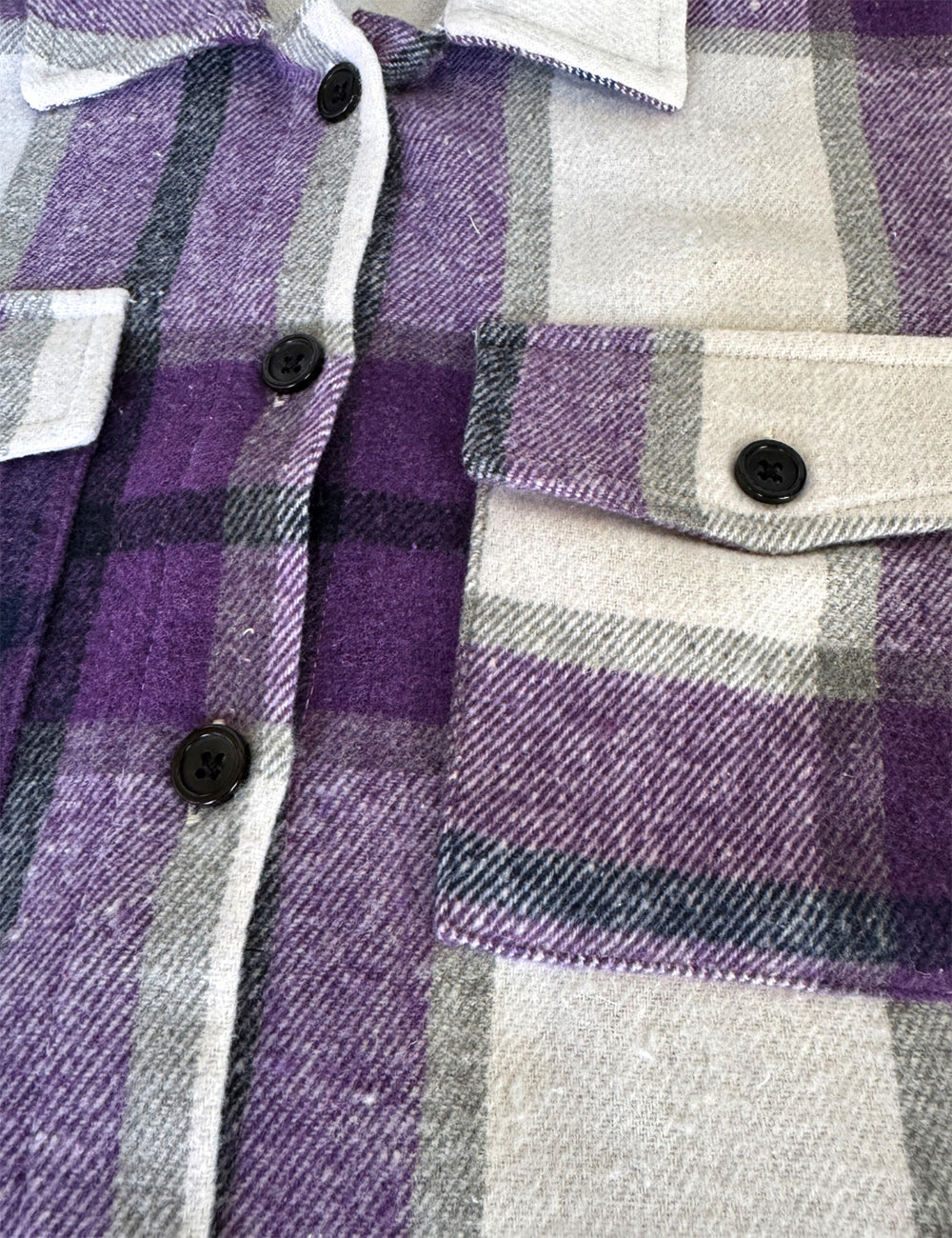close up of the purple, grey, white, and black plaid jacket