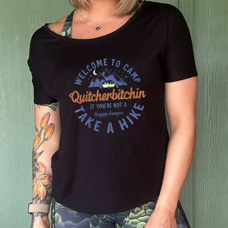 Black colored shirt with a mountain and campervan graphic on it that says "Welcome To Camp Quitcherbitchin if you're not a happy camper take a hike"