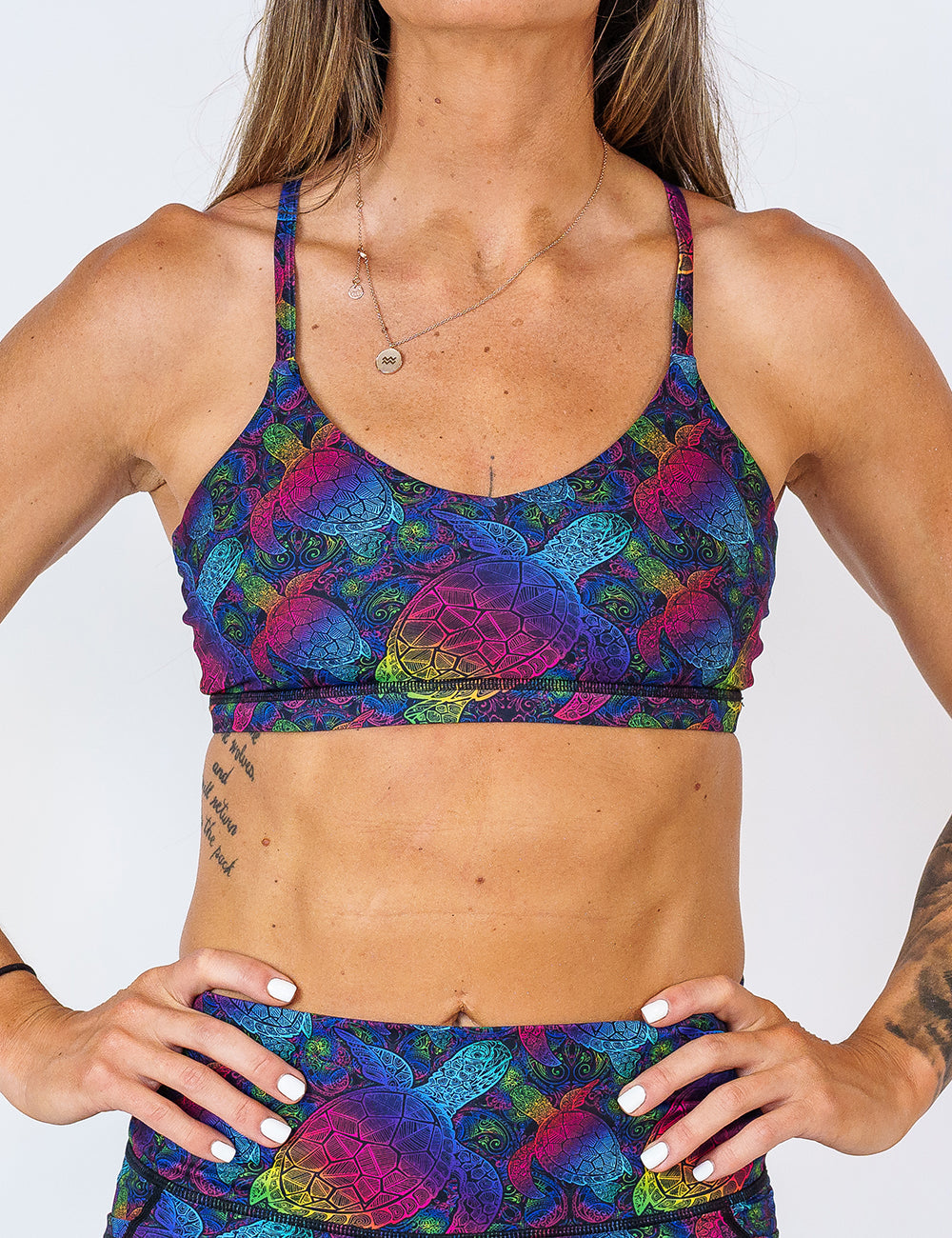 front of the move free pink, yellow, blue, green and purple ombre turtle print bra against a white background