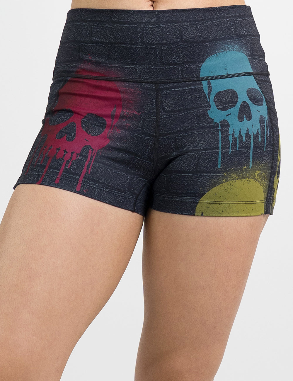 model wearing the black brick patterned 2.5 inch shorts withe blue, red, and yellow skull spray paint patterns against a white background