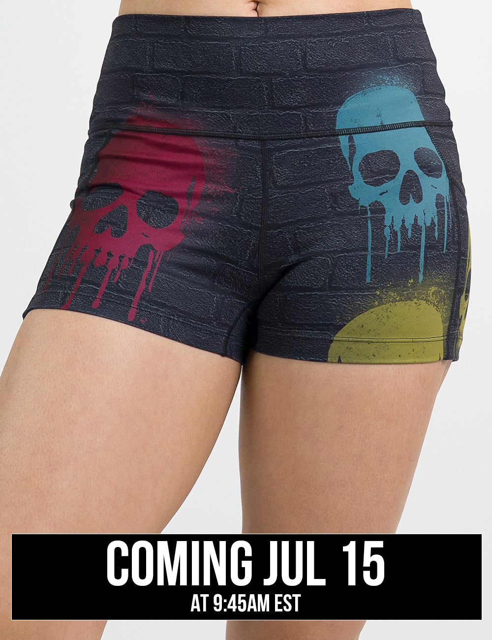 model wearing the black brick patterned 2.5 inch shorts withe blue, red, and yellow skull spray paint patterns against a white background
