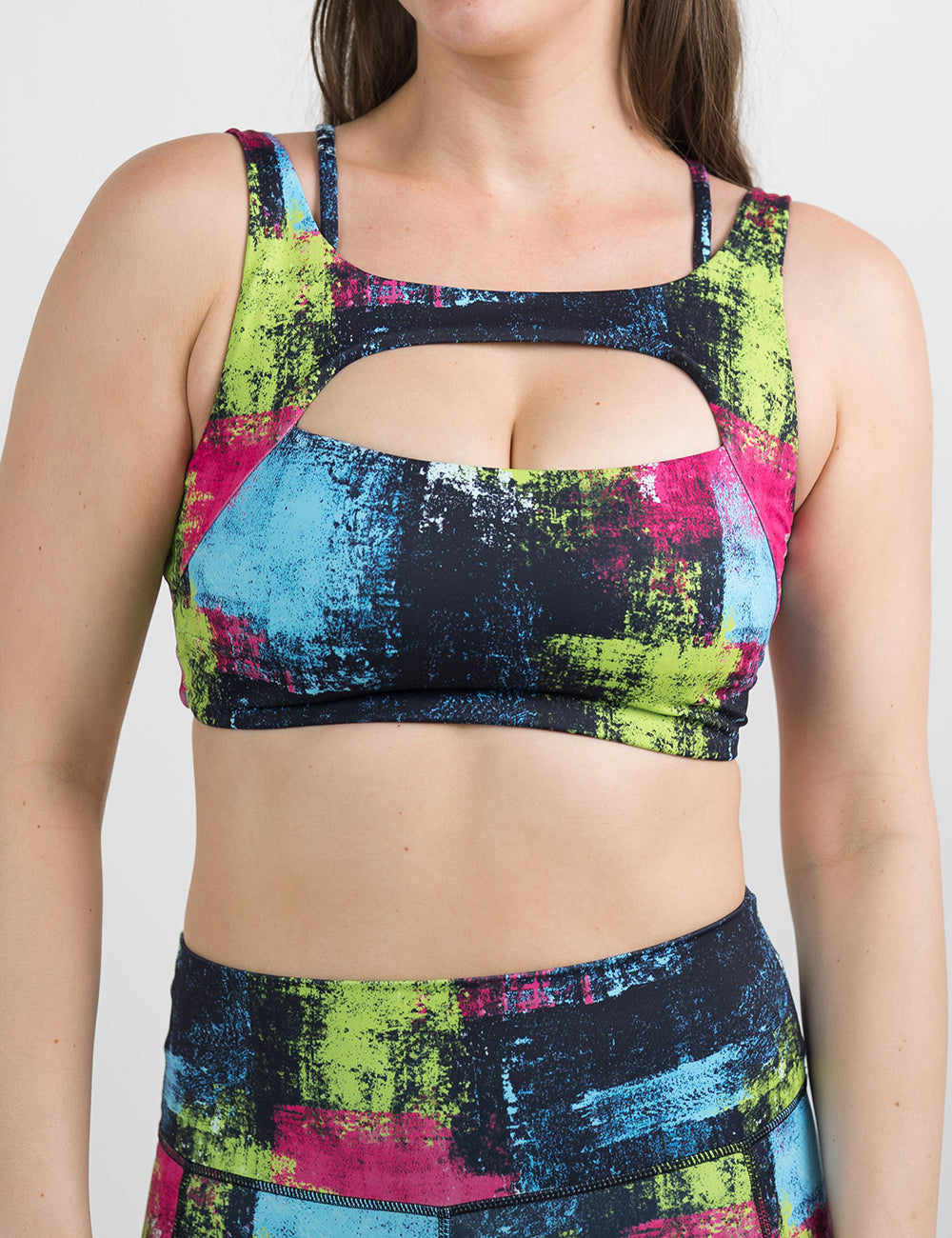 front of the green, pink, and blue grunge pattern bra against a white background