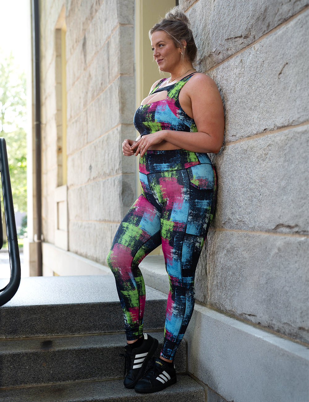 model wearing the green, pink, and blue grunge pattern full length leggings and sports bra