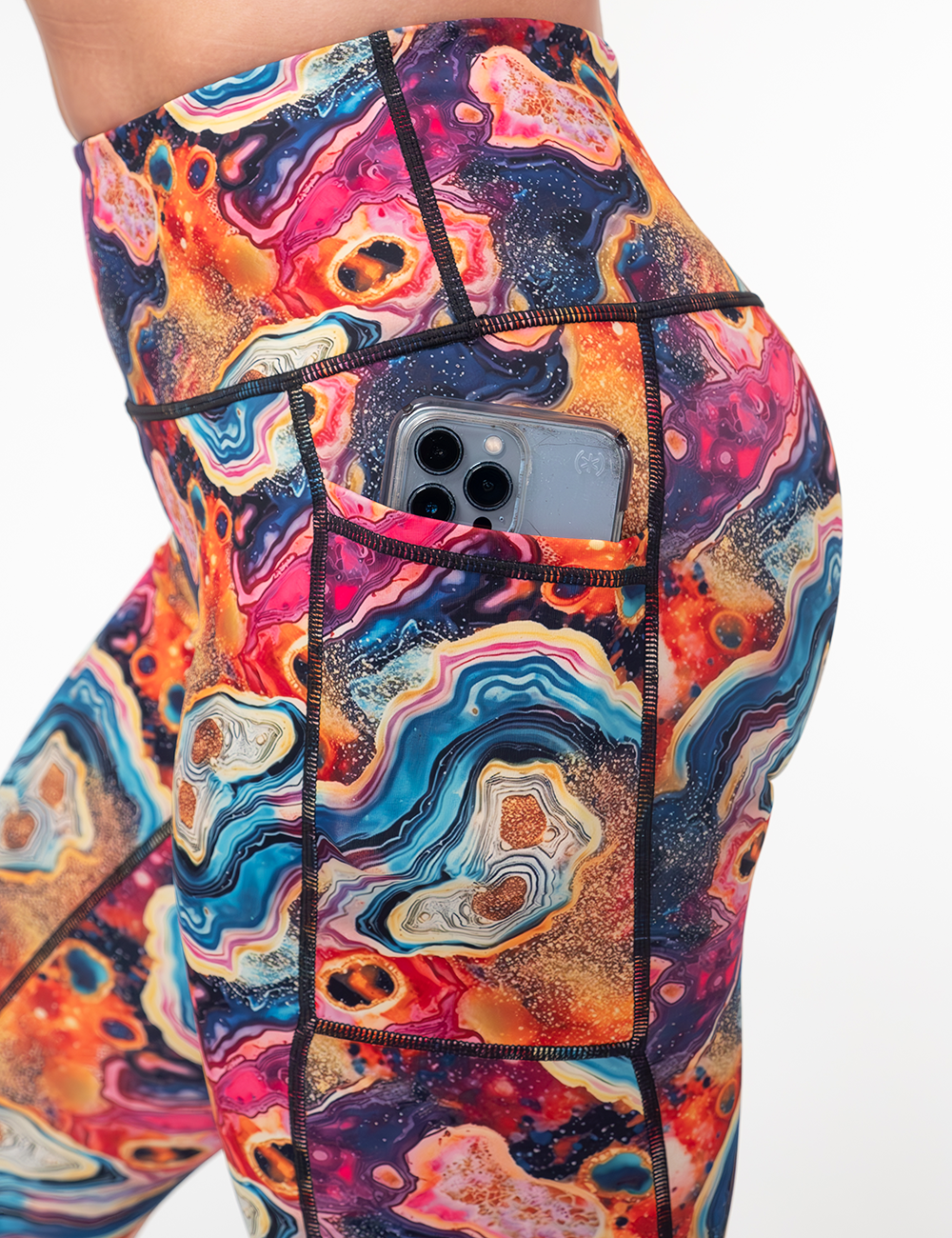 close up of the colorful marble patterned leggings pocket holding a phone
