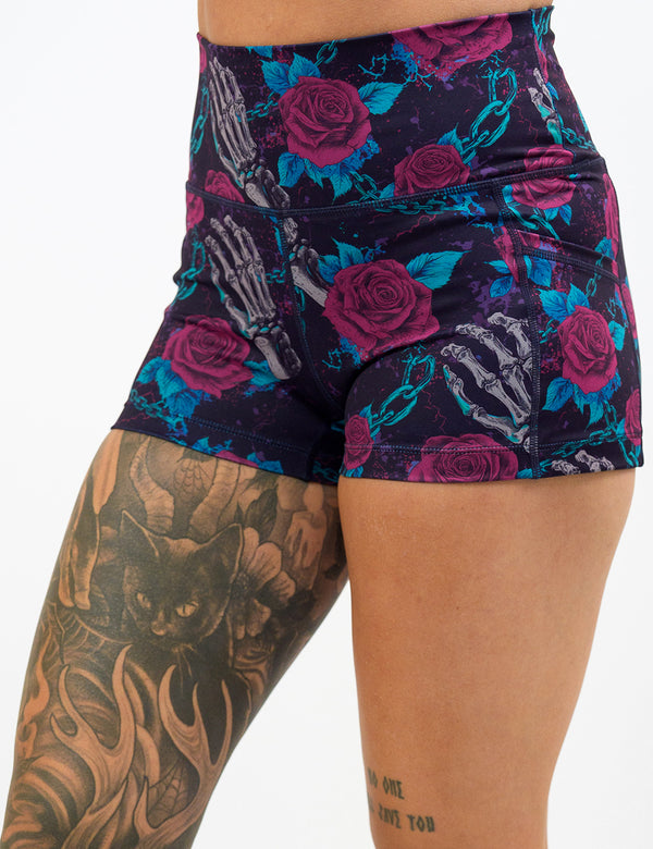 close up of the roses and skeleton hands connected by chain links pattern 2.5 inch shorts against a white background