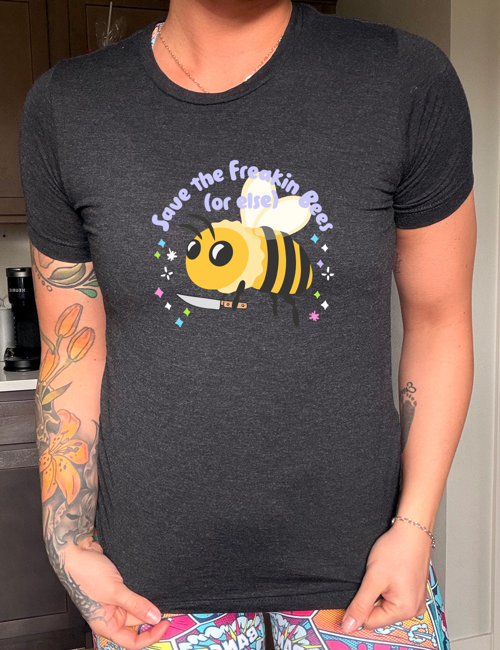 Black colored shirt with a bee holding a knife graphic on it that says "Save The Freakin Bees (Or Else)" 