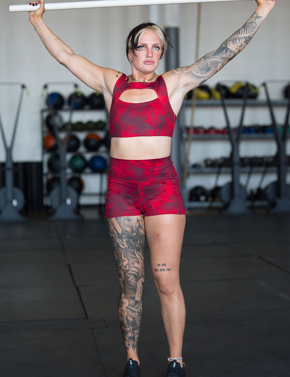 model wearing the red tie dye 2.5 inch shorts and sports bra in the gym