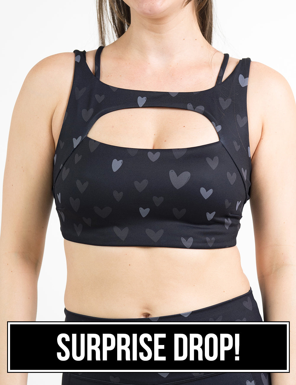 front of the black vista bra with a light and dark grey heart pattern against a white background, surprise drop