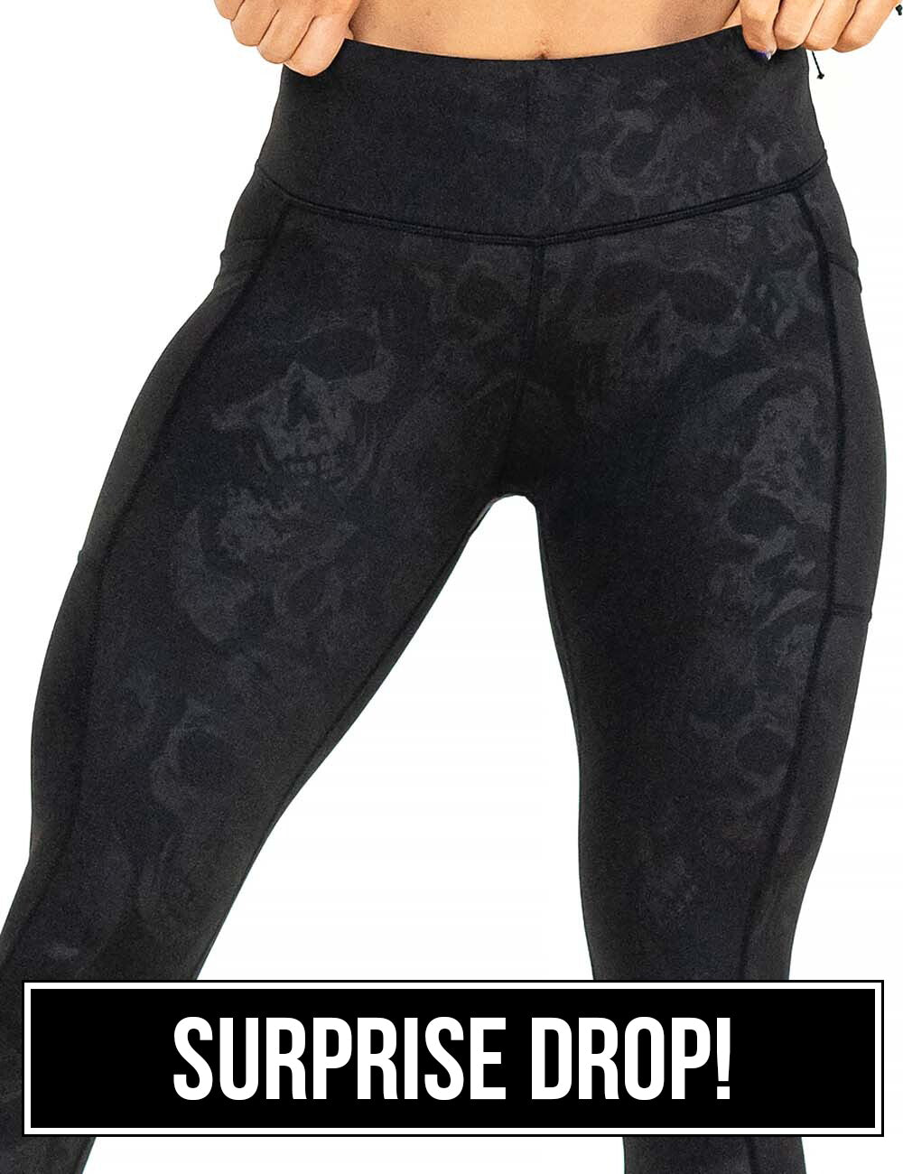 front of the black leggings with a dark grey skull pattern against a white background, surprise drop