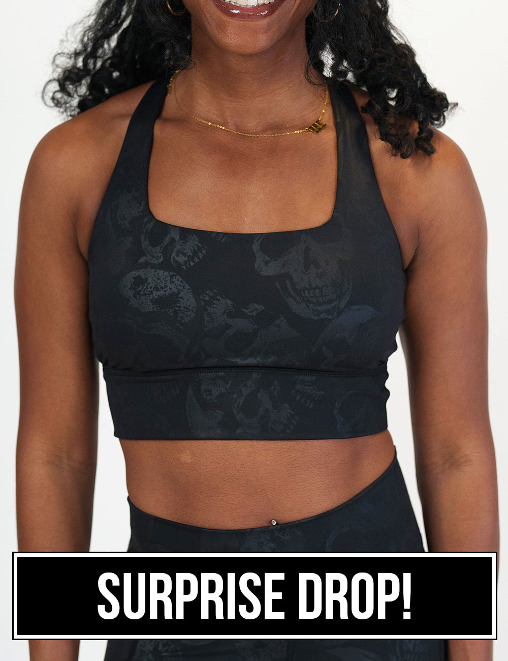 front of the black longline bra with a dark grey skull pattern against a white background, surprise drop