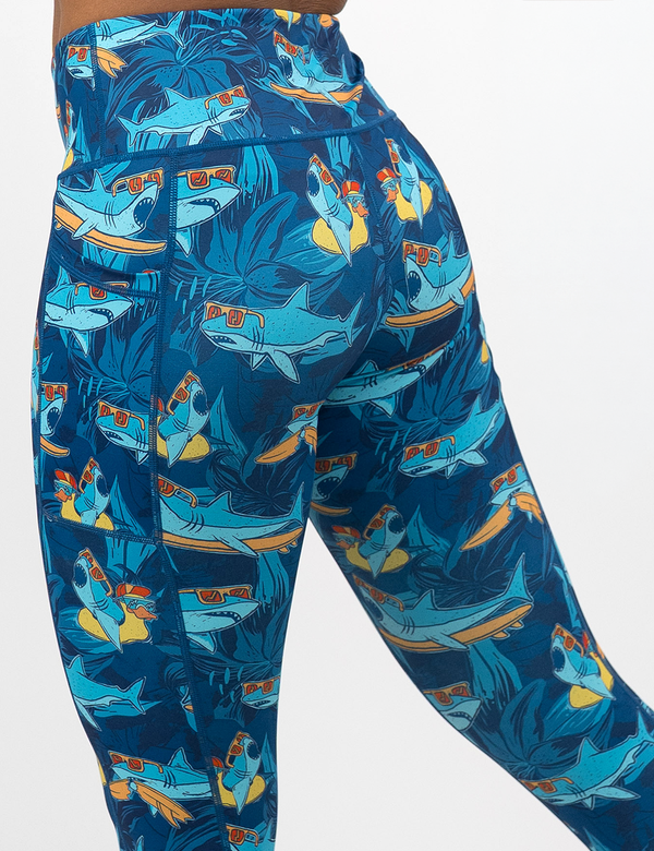 back of the cartoon sharks surfboarding with sunglasses leggings against a white background
