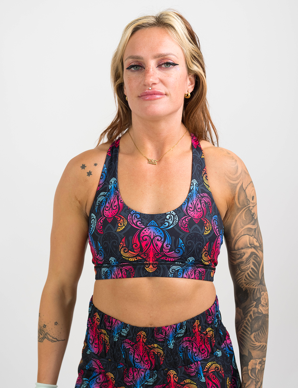 model wearing the rainbow turtle against a dark background butterfly back bra against a white background