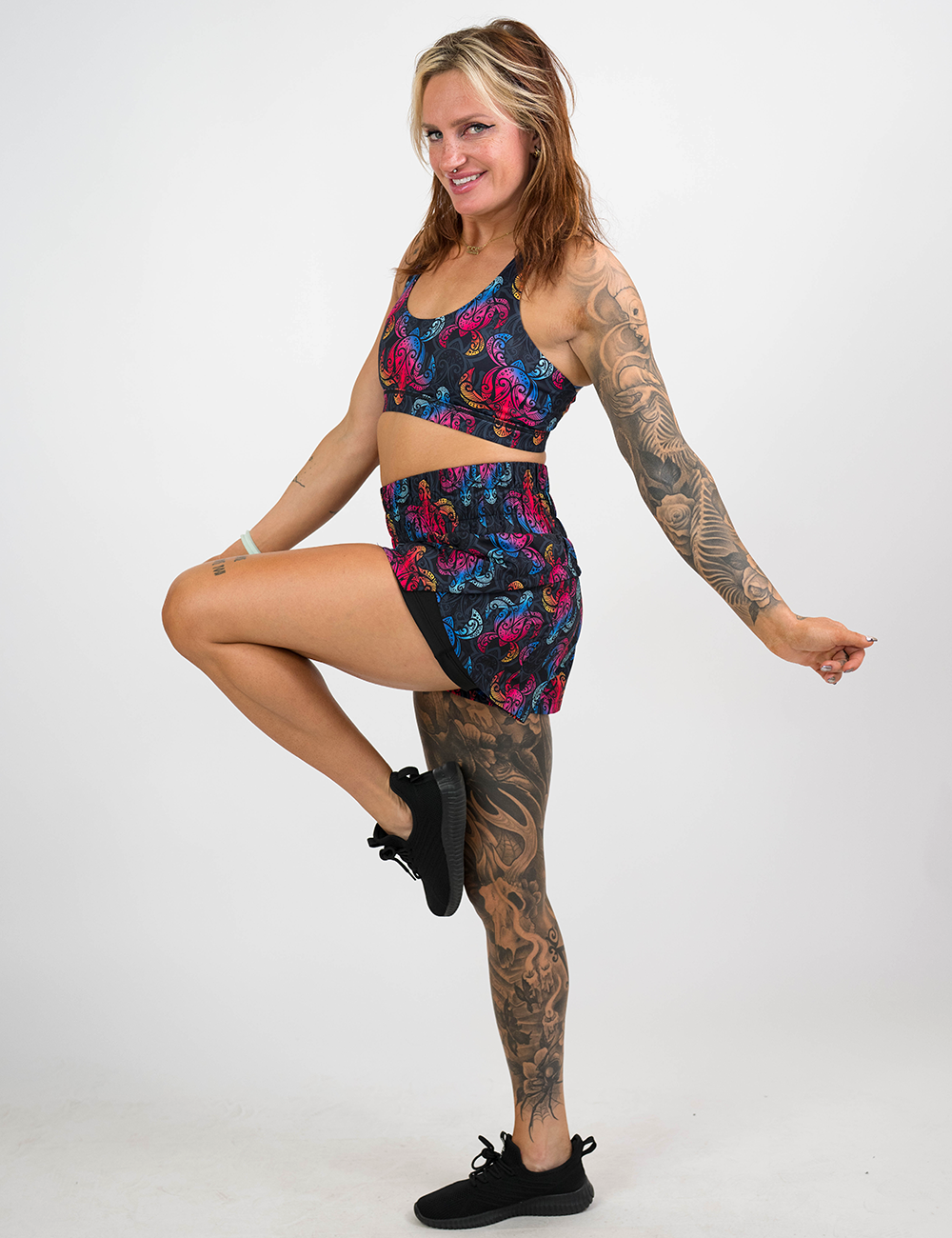 model wearing the rainbow turtle against a dark background shorts and bra against a white background