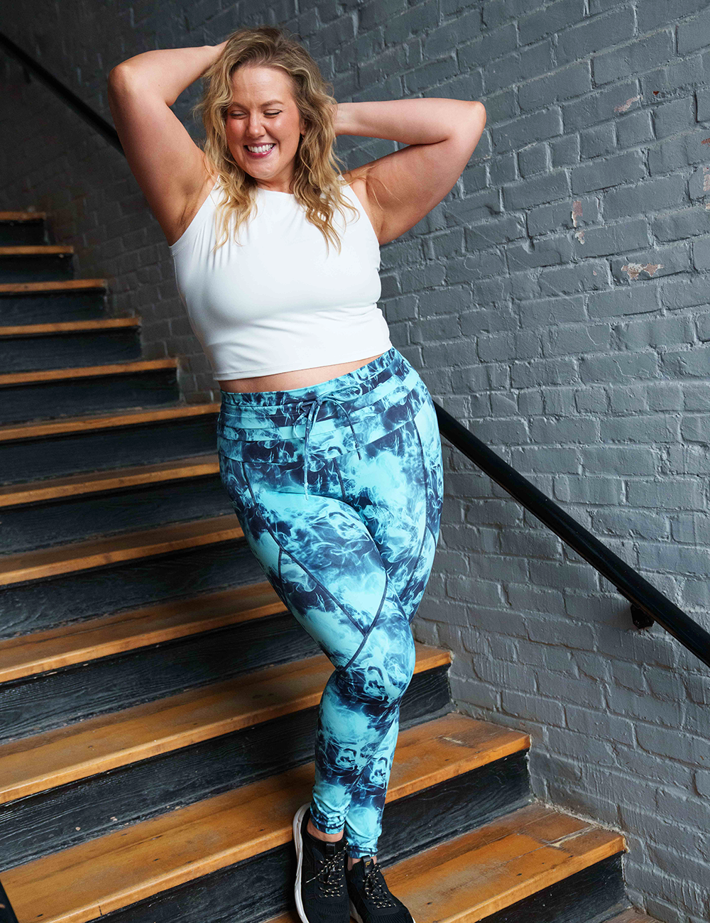 smoke show leggings and white top posing in a stairwell