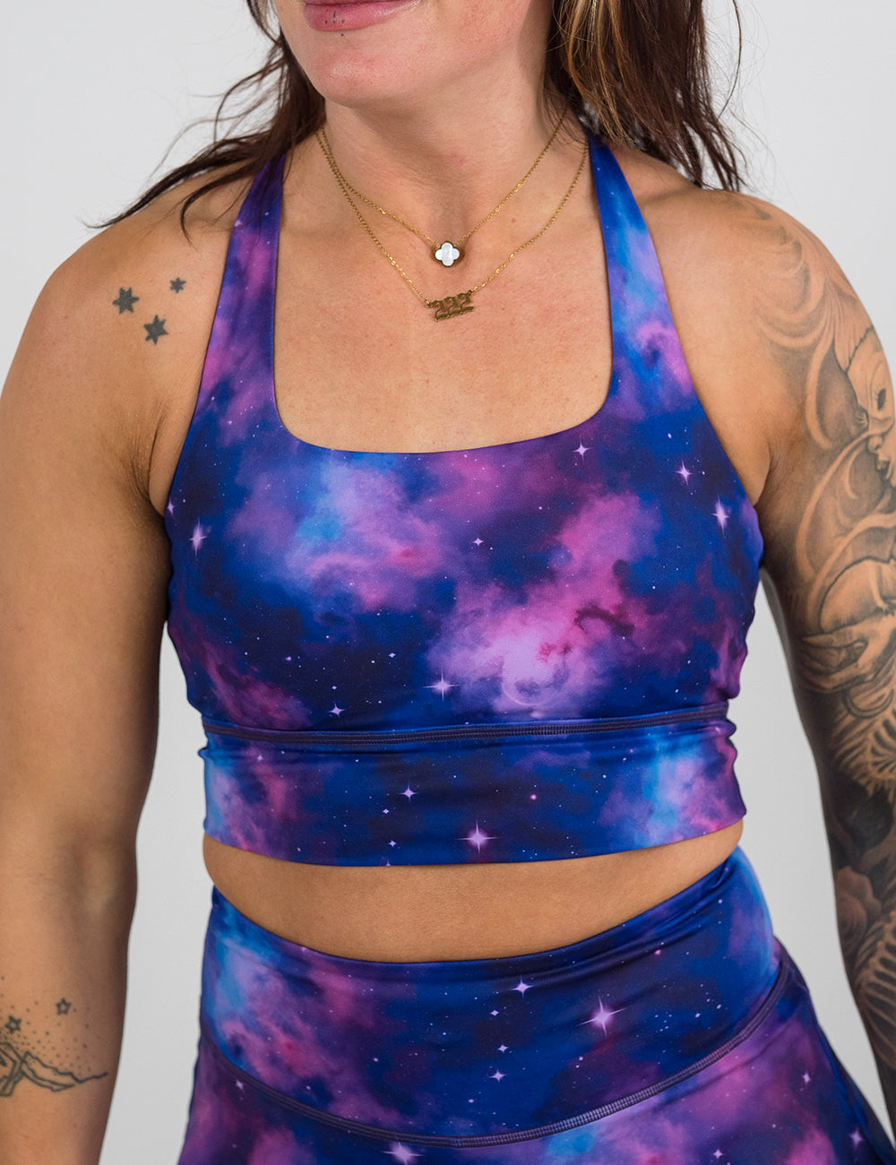 front of the purple and blue space longline bra against a white background