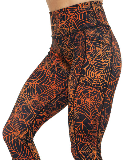 front of the orange spider webs against a black background leggings against a white background