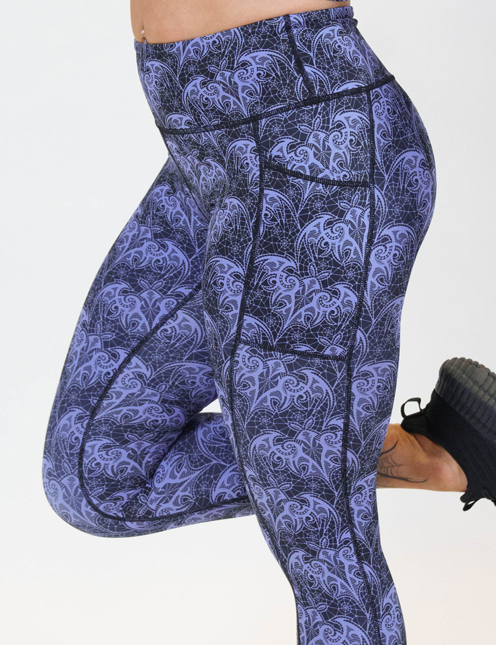 front of the purple lace bats leggings against a white background