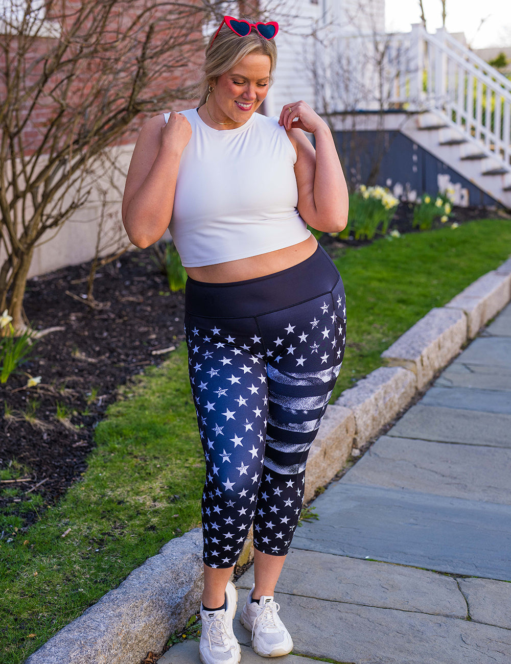 model wearing the black capri leggings with white American flag design outside 