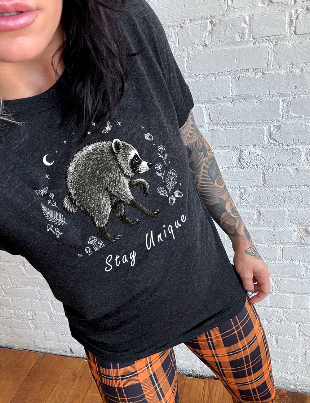 front of the black "stay unique" raccoon  unisex tee 